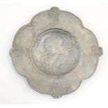 An Art Nouveau WMF style pewter dish with lobed edge, the central decoration depicting a woman