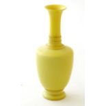 A Chinese yellow glazed baluster vase with an elongated neck and flared rim. Approx. 5 3/4'' high.
