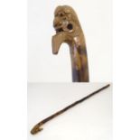 A 20thC Oriental walking cane with a carved head handle and hardwood shank. Approx. 37 1/4" Please