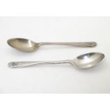 A pair of silver teaspoons with crossed golf club and ball decorations to handles. Hallmarked