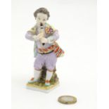 A Continental figure modelled as a boy playing a musical instrument. Marked under. Approx. 4 1/4"