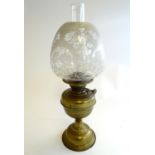An early 20thC oil lamp, the brass column with integral reservoir supporting an etched and frosted