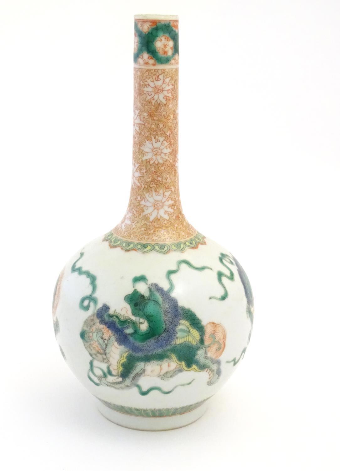 A Chinese bottle vase decorated with stylised foo dogs / dragons. The neck with floral and foliate