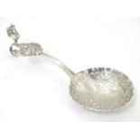 A Continental white metal caddy spoon with landscape scene to bowl and peacock decoration to