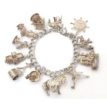 A charm bracelet with 12 various silver and silver plate charms Please Note - we do not make