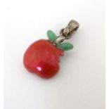 A silver pendant / charm formed as a bitten apple with enamel decoration. ¾'' long Please Note -