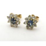 A pair of stud earrings set with green spinel and white stones in a cluster setting. approx. 1/4"