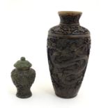 Two Oriental carved lacquer vases, one decorated with dragons among stylised clouds, the other a