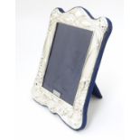 A photograph frame with silver surround having Art Nouveau style decoration. Hallmarked London 2020.