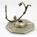 An Indian silver plate and brass standish with an octagonal base, central glass bottle, pen rest