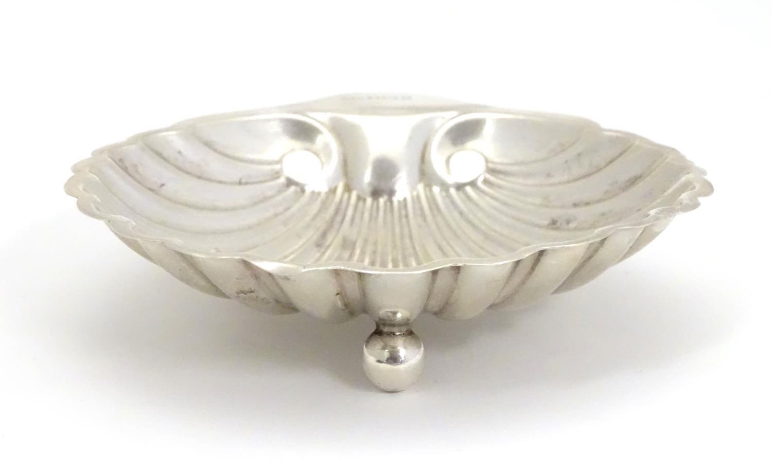 A silver scallop-shaped dish raised on three bun feet. Hallmarked Sheffield 1910 maker Harrison - Image 5 of 5