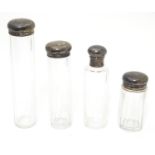 4 assorted cut glass dressing table bottles with silver tops. The tallest 6 1/2" Please Note - we do