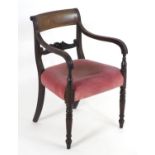 A Regency mahogany carver chair with a reeded frame, carved mid rail and upholstered seat above