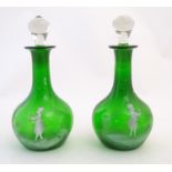 Two Mary Gregory style green glass decanters / carafes with white enamel figural decoration. each