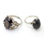 Two silver rings, one set with cats eye cabochon ( ring size approx K) , the other smoky quartz in a