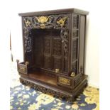 A 20thC oriental shrine cabinet with a moulded top above pierced and scrolled carvings with gilt