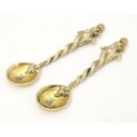 An unusual pair of gilded white metal salt spoons, the bowls with crescent decoration and engraved