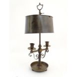 A French Bouillotte lamp with twin candle sconces, the shade engraved with naive depictions of a