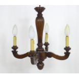 A 20thC carved wooden four branch pendant light fitting / electrolier. Approx 21" high x 20" wide