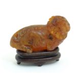 An Oriental carved amber model of a guardian lion / shishi. Approx. 1" high x 2" long Please