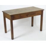 A mid 20thC fruitwood and oak desk with a rectangular top above a single short drawers and raised on