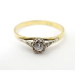 An 18ct gold ring set with diamond solitaire flanked by 2 diamonds. Ring size approx S Please Note -