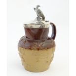 A Victorian salt glaze two tone harvest jug with silver mounts and lid surmounted by an eagle,