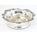 A late 19thC / early 20thC silver plate coaster with turned wooden base. 7 1/4" wide. Please