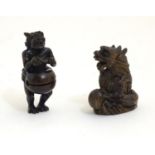 Two Japanese netsukes, one depicting a dragon with a pearl, signed under. The other netsuke modelled