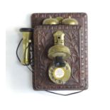 A 20thC wall mounting telephone with carved wooden case and brass fittings. Approx. 12" high