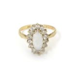 A 9ct gold ring set with central opal bordered by white stones. Ring size approx L Please Note -