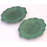 A pair of Wedgwood majolica oval plates with lobed rims and green lustre glaze, decorated with
