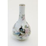 A Chinese globular vase with an elongated neck decorated with peacocks and flowers in a landscape,