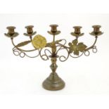 An early 20thC brass five branch candelabra with scrolling wheat sheaf, vine leaf, and flower