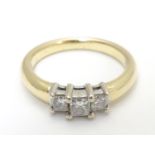 A 14kt gold ring set with trio of diamonds. The central diamond approx. 1/8" diamond Please Note -