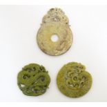 Three Oriental carved roundels, comprising two hardstone examples with stylised dragons, and one