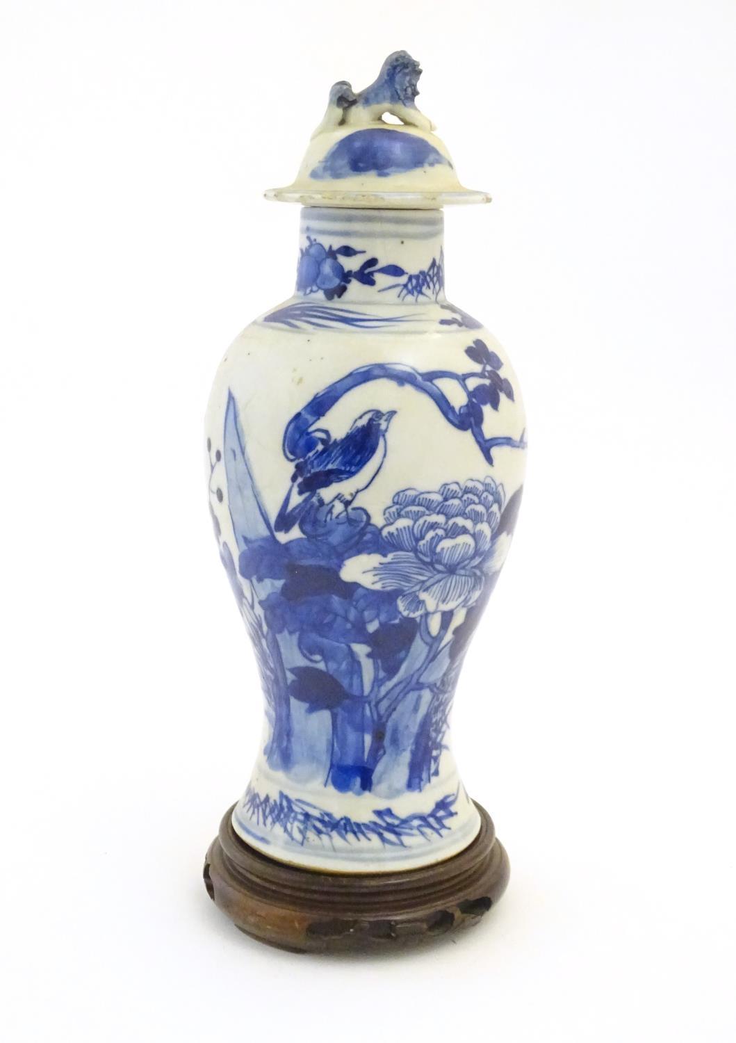 A Chinese blue and white vase and cover with floral, foliate and bird detail. The lid with foo dog