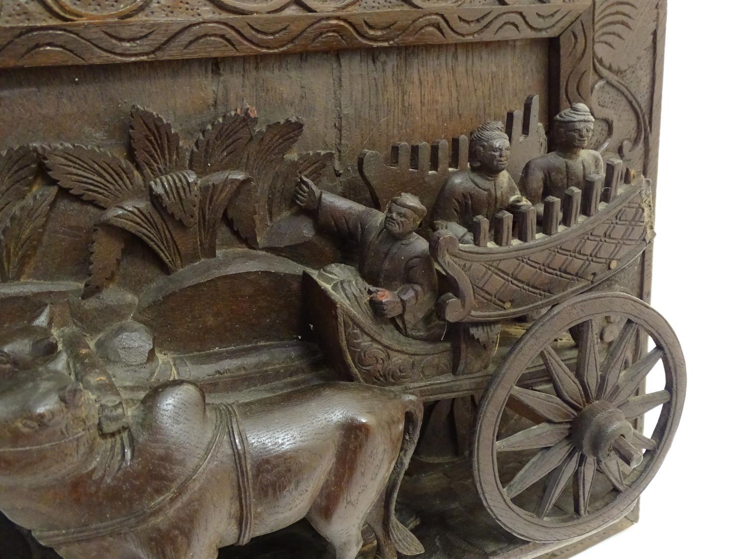 A 20thC Chinese carved wood wall plaque depicting oxon pulling a cart with figures, the border - Image 2 of 7