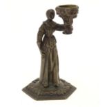 A 19thC cast bronze figure of a woman holding a vase aloft on a hexagonal base with foliate
