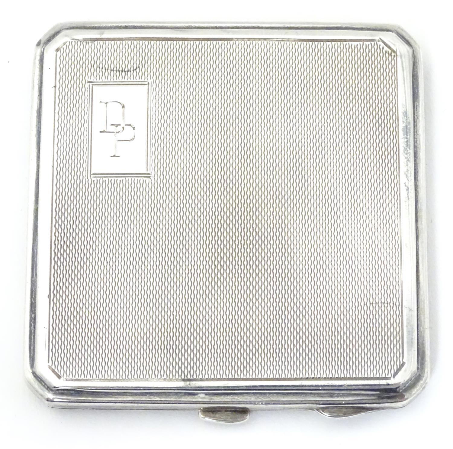 An Art Deco silver compact with engine turned decoration. Hallmarked Birmingham 1947maker Joseph