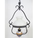 A pendant hanging oil lamp with painted ceramic reservoir and white glass shade. Converted for