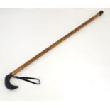 A 20thC walking stick with a buffalo horn handle and a carved shank. Approx. 36" Please Note - we do