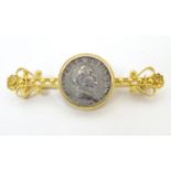 A Victorian gold and gilt metal bar brooch with filigree style decoration set with coin like