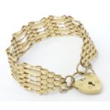 A 9ct gold bracelet with padlock clasp . Approx 7 1/2" long x 3/4" wide (approx 13g) Please Note -