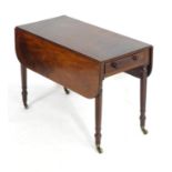 A large early / mid 19thC mahogany Pembroke table with two drop flaps above a single short drawer