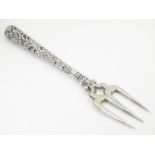 A Victorian silver bread fork with an embossed handle, the central tine hallmarked Birmingham
