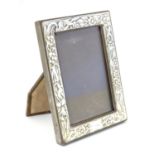 A Silver fronted photograph frame with floral decoration. Import hallmarks for London 1989,