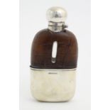 A Victorian glass hip flask with half leather covering, silver mounts and beaker to lower,