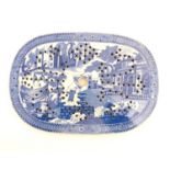 An English blue and white strainer with chinoiserie decoration depicting a fishing village with