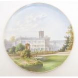 A decorative charger depicting a view of a white building and a tower. Approx. 13 1/4" diameter